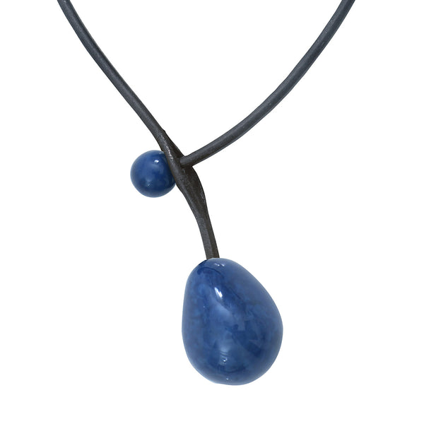 Il s'agit d'un  Collier en ivoire végétal  bleu marine avec une ouverture devant en forme de boutonnière sur le tour de cou en cuir. 